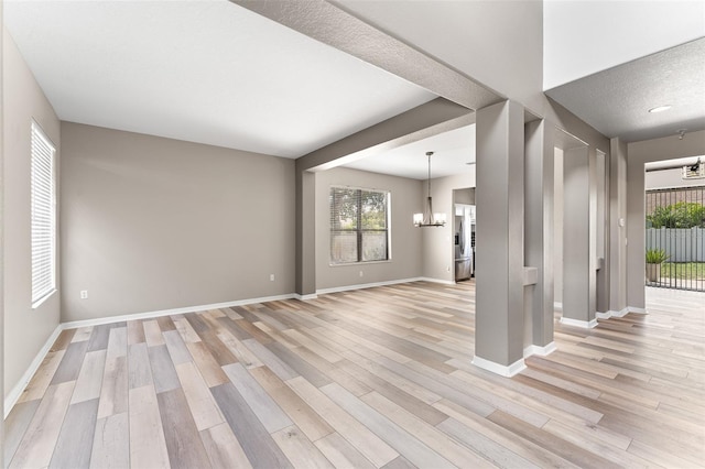 1291 Blackrush Dr, Tarpon Springs, FL 34689 - unfurnished living room with a chandelier and light wood-type flooring