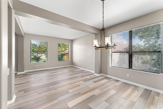 1291 Blackrush Dr, Tarpon Springs, FL 34689 - unfurnished dining area featuring a chandelier and light wood-type flooring