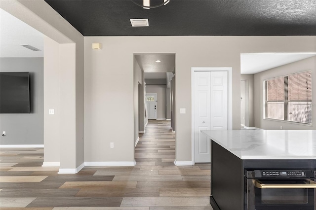 1291 Blackrush Dr, Tarpon Springs, FL 34689 - kitchen with wood finished floors, light countertops, and black oven