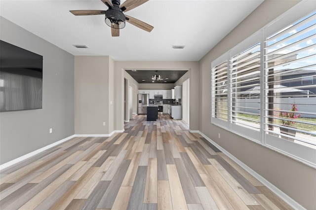 1291 Blackrush Dr, Tarpon Springs, FL 34689 - unfurnished living room with light wood-style floors and a ceiling fan
