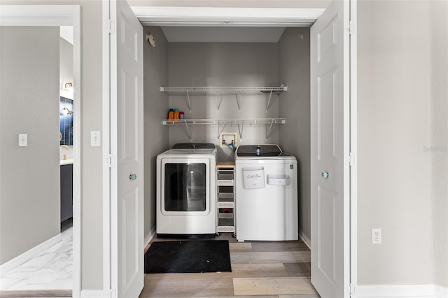 1291 Blackrush Dr, Tarpon Springs, FL 34689 - washroom with washer and clothes dryer and wood finished floors
