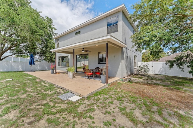 1291 Blackrush Dr, Tarpon Springs, FL 34689 - rear view of property featuring ceiling fan, stucco siding, a fenced backyard, a patio, and a gate