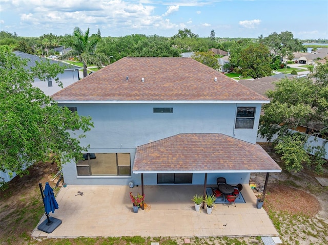 1291 Blackrush Dr, Tarpon Springs, FL 34689 - back of house with a patio, a shingled roof, and stucco siding