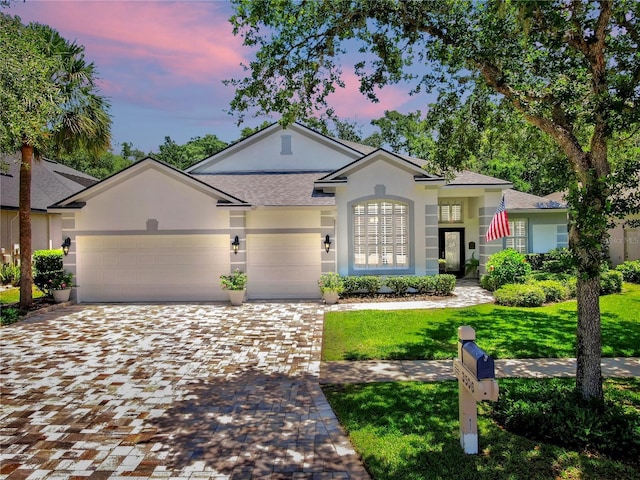 3506 Cordgrass Dr, Valrico, FL 33596 - view of front of house with a lawn, a garage, stucco siding, decorative driveway, and a shingled roof