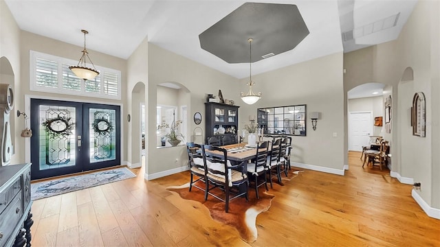 3506 Cordgrass Dr, Valrico, FL 33596 - dining room featuring a towering ceiling, light wood-type flooring, arched walkways, and french doors