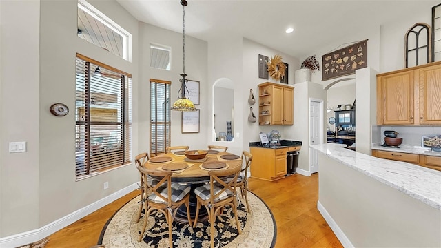 3506 Cordgrass Dr, Valrico, FL 33596 - dining area with arched walkways, a towering ceiling, light wood-type flooring, and recessed lighting