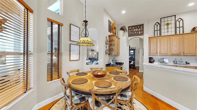 3506 Cordgrass Dr, Valrico, FL 33596 - dining area featuring arched walkways, light wood-style floors, recessed lighting, and a towering ceiling