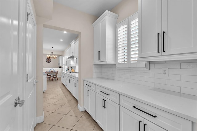 6207 Bleeker St, Riverview, FL 33578 - kitchen with white cabinetry, light countertops, light tile patterned floors, tasteful backsplash, and a chandelier