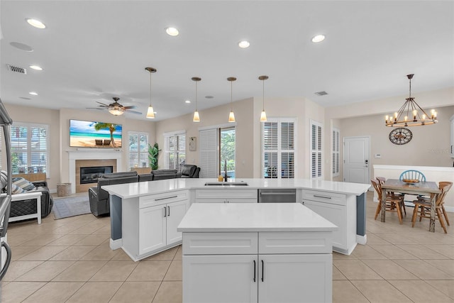 6207 Bleeker St, Riverview, FL 33578 - kitchen featuring a center island, stainless steel dishwasher, light tile patterned flooring, a glass covered fireplace, and a ceiling fan