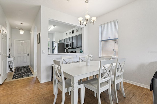 1052 Calabria Ave, Davenport, FL 33897 - dining room with wood finished floors, a chandelier, and healthy amount of natural light