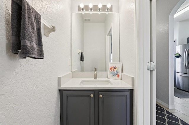 1052 Calabria Ave, Davenport, FL 33897 - bathroom featuring tile patterned floors, a textured wall, and vanity