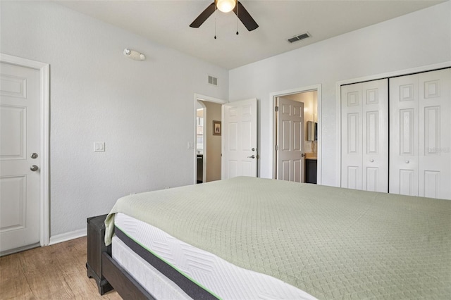1052 Calabria Ave, Davenport, FL 33897 - bedroom featuring wood finished floors, a closet, ceiling fan, and connected bathroom