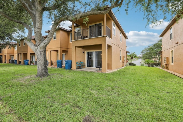 1052 Calabria Ave, Davenport, FL 33897 - rear view of house with a balcony, stucco siding, and a lawn