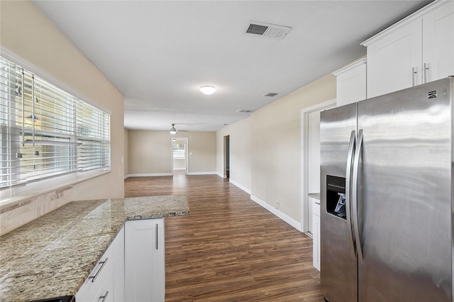 10502 Orange Blossom Ln, Seminole, FL 33772 - kitchen with stainless steel fridge, dark wood-style flooring, white cabinets, light stone countertops, and open floor plan
