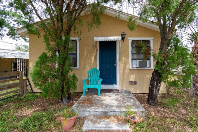 1144AND1142 7th St NW, Largo, FL 33770 - property entrance with stucco siding and cooling unit