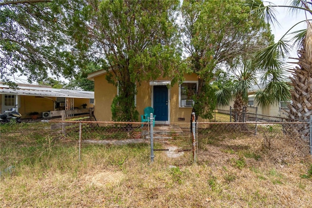1144AND1142 7th St NW, Largo, FL 33770 - view of property hidden behind natural elements featuring stucco siding, a fenced front yard, and cooling unit