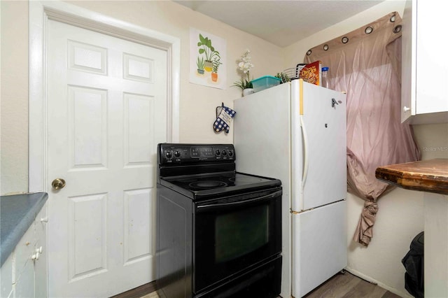 1144AND1142 7th St NW, Largo, FL 33770 - kitchen featuring black electric range oven, freestanding refrigerator, and wood finished floors