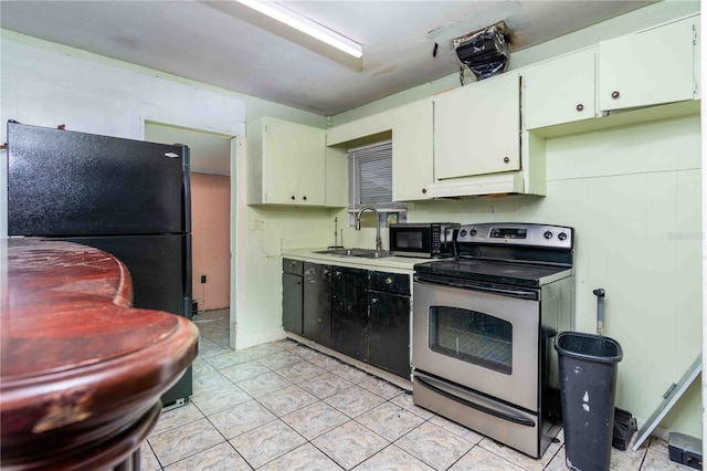 1144AND1142 7th St NW, Largo, FL 33770 - kitchen with black appliances, white cabinets, light countertops, light tile patterned flooring, and under cabinet range hood