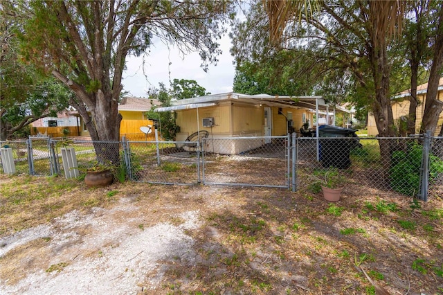 1144AND1142 7th St NW, Largo, FL 33770 - rear view of property featuring a gate, an attached carport, and driveway