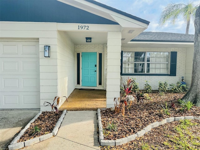 1972 Briarwood St, Dunedin, FL 34698 - property entrance featuring brick siding and a garage