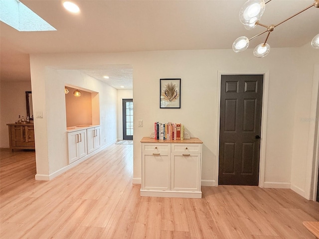 1972 Briarwood St, Dunedin, FL 34698 - hall with light wood-style floors, a skylight, and recessed lighting