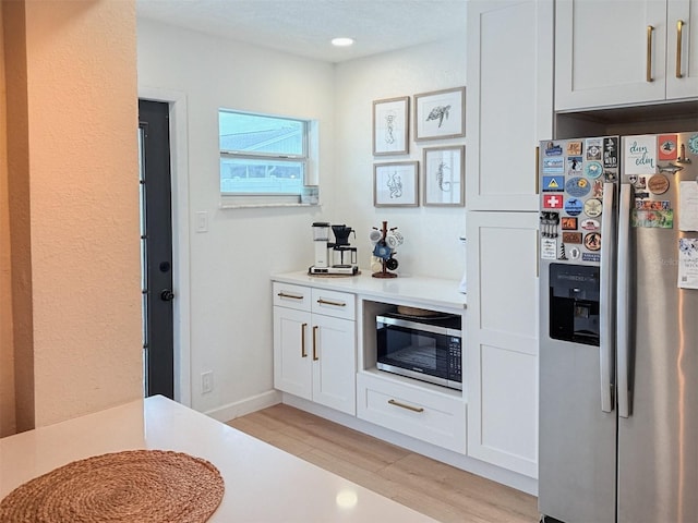 1972 Briarwood St, Dunedin, FL 34698 - kitchen with appliances with stainless steel finishes, light countertops, light wood-style floors, white cabinets, and recessed lighting