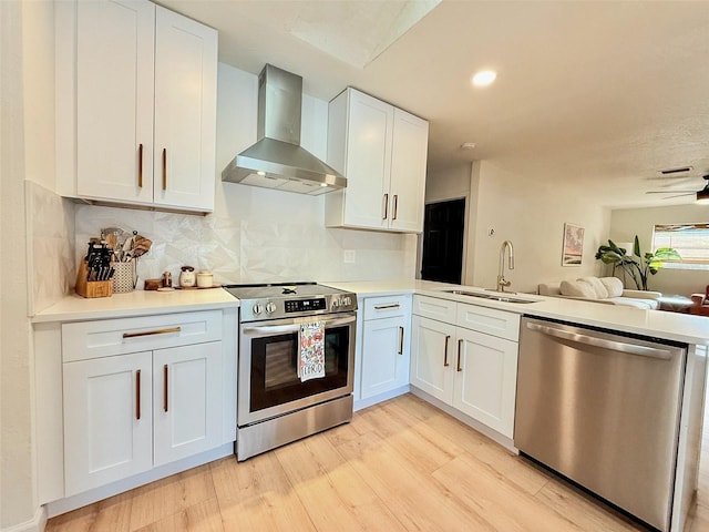 1972 Briarwood St, Dunedin, FL 34698 - kitchen with appliances with stainless steel finishes, wall chimney range hood, open floor plan, light wood-style flooring, and decorative backsplash