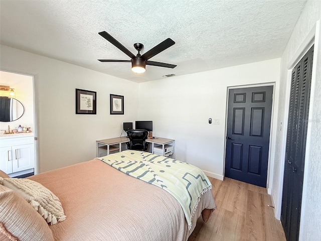 1972 Briarwood St, Dunedin, FL 34698 - bedroom featuring light wood-style flooring, a closet, a textured ceiling, and ceiling fan