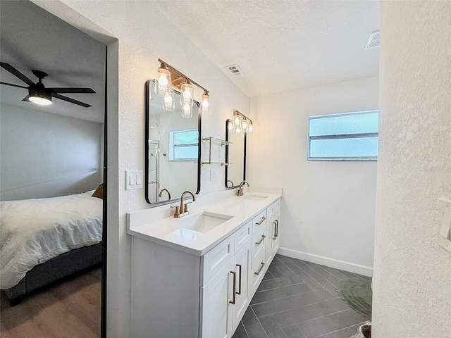 1972 Briarwood St, Dunedin, FL 34698 - ensuite bathroom featuring double vanity, a ceiling fan, a textured ceiling, a textured wall, and tile patterned floors