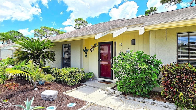 13 Windrush Bay Dr, Tarpon Springs, FL 34689 - entrance to property with roof with shingles and stucco siding