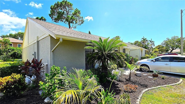 13 Windrush Bay Dr, Tarpon Springs, FL 34689 - view of side of home with stucco siding and roof with shingles