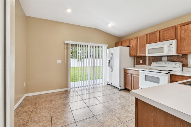 8020 Carriage Pointe Dr, Gibsonton, FL 33534 - kitchen with white appliances, light countertops, vaulted ceiling, decorative backsplash, and light tile patterned floors