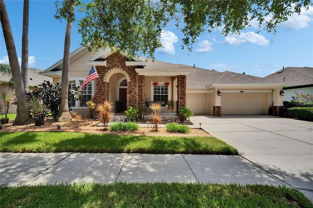 8704 Winsome Way, Land O Lakes, FL 34637 - view of front of property featuring a garage, stucco siding, stone siding, and driveway