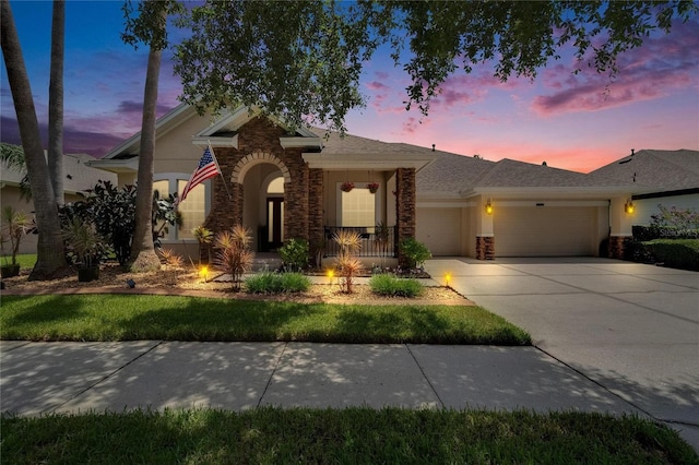 8704 Winsome Way, Land O Lakes, FL 34637 - view of front facade with a garage, driveway, stucco siding, and stone siding