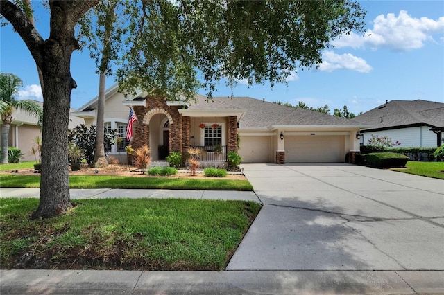 8704 Winsome Way, Land O Lakes, FL 34637 - view of front facade featuring a garage, driveway, stone siding, stucco siding, and a front lawn