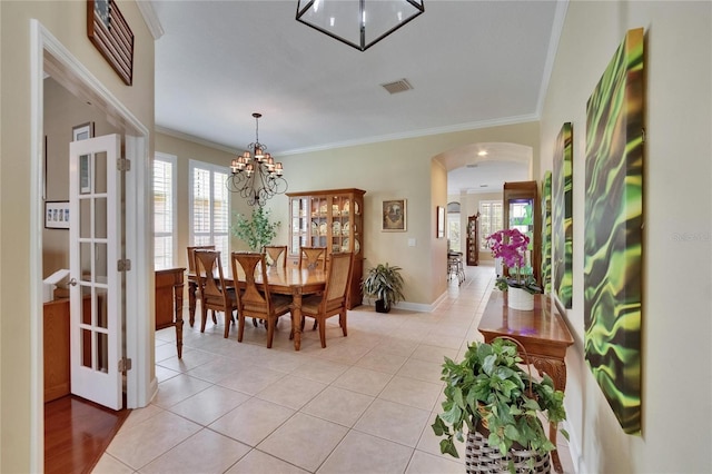 8704 Winsome Way, Land O Lakes, FL 34637 - dining area with arched walkways, crown molding, healthy amount of natural light, light tile patterned flooring, and a chandelier