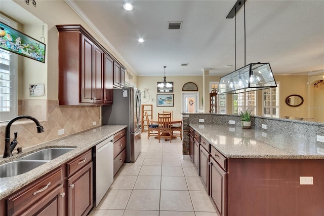 8704 Winsome Way, Land O Lakes, FL 34637 - kitchen with ornamental molding, stainless steel appliances, decorative light fixtures, light stone countertops, and tasteful backsplash