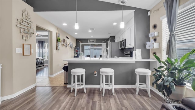 7120 Forest Mere Dr, Riverview, FL 33578 - kitchen with white cabinetry, plenty of natural light, a breakfast bar, and recessed lighting