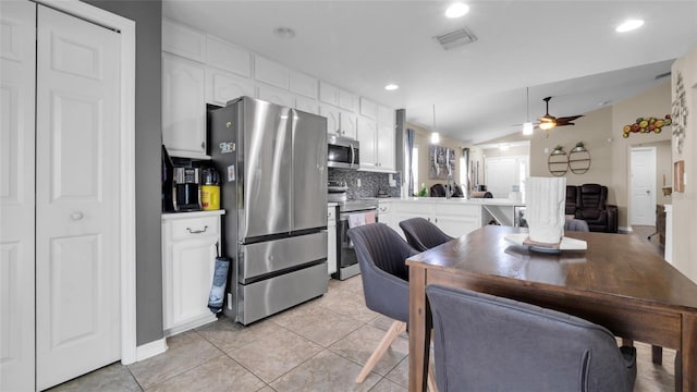 7120 Forest Mere Dr, Riverview, FL 33578 - kitchen featuring appliances with stainless steel finishes, ceiling fan, white cabinetry, backsplash, and a peninsula