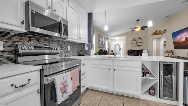 7120 Forest Mere Dr, Riverview, FL 33578 - kitchen featuring appliances with stainless steel finishes, beverage cooler, decorative backsplash, a peninsula, and vaulted ceiling