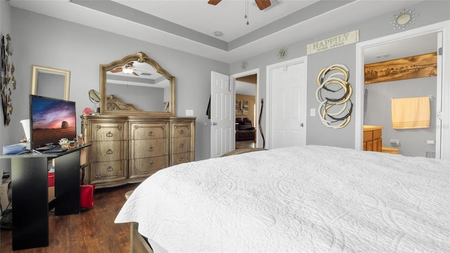 7120 Forest Mere Dr, Riverview, FL 33578 - bedroom with dark wood-style flooring, a tray ceiling, connected bathroom, and a ceiling fan