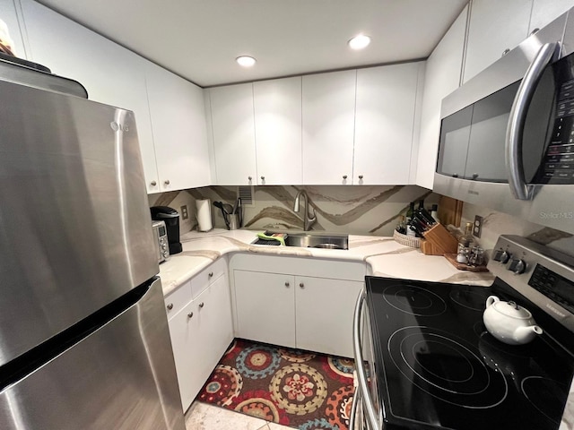 880 Mandalay Ave Unit N311, Clearwater Beach, FL 33767 - kitchen with appliances with stainless steel finishes, light countertops, white cabinetry, and recessed lighting
