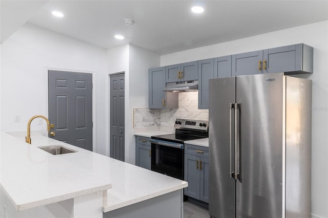 22716 Penny Loop, Land O Lakes, FL 34639 - kitchen featuring stainless steel appliances, under cabinet range hood, a peninsula, decorative backsplash, and recessed lighting