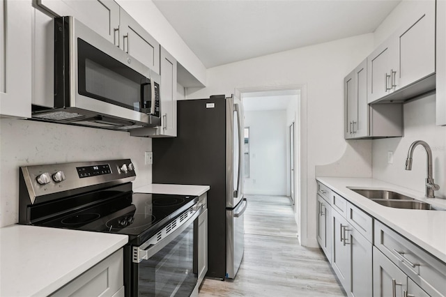 607 E River Dr, Temple Terrace, FL 33617 - kitchen featuring appliances with stainless steel finishes, light countertops, light wood-type flooring, and gray cabinetry