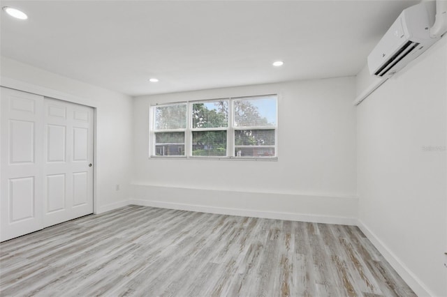 607 E River Dr, Temple Terrace, FL 33617 - unfurnished bedroom featuring a wall mounted AC, light wood-style flooring, recessed lighting, and a closet