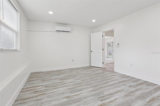 607 E River Dr, Temple Terrace, FL 33617 - unfurnished room with a wall mounted AC, light wood-style flooring, and recessed lighting
