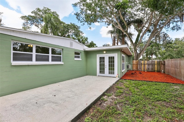 607 E River Dr, Temple Terrace, FL 33617 - back of property with french doors, a patio, and a fenced backyard