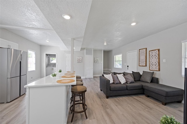 1048 W Lime St, Lakeland, FL 33815 - living area with a textured ceiling, light wood finished floors, washer / dryer, and recessed lighting