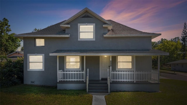 1048 W Lime St, Lakeland, FL 33815 - view of front of house featuring covered porch, stucco siding, a shingled roof, and a front lawn