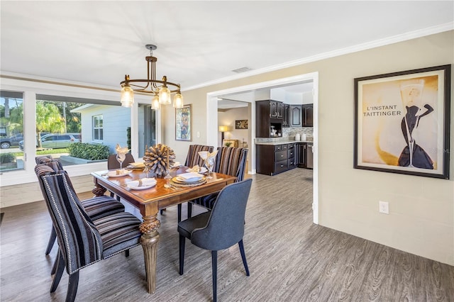610 Cordova Blvd NE, Saint Petersburg, FL 33704 - dining area with a chandelier, wood finished floors, and ornamental molding